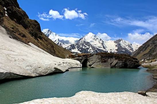 High altitude glacial lake Marinda Tal surrounded by snow-capped Himalayan peaks near Har Ki Dun