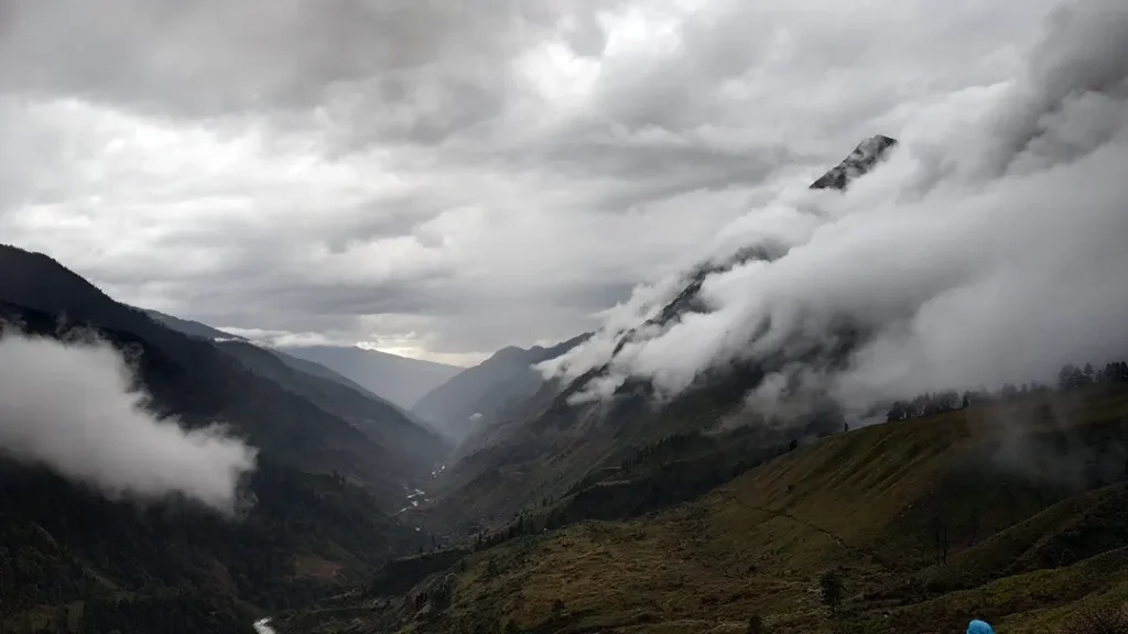 Vibrant green alpine meadows and misty mountain trails during monsoon in Har Ki Dun trek