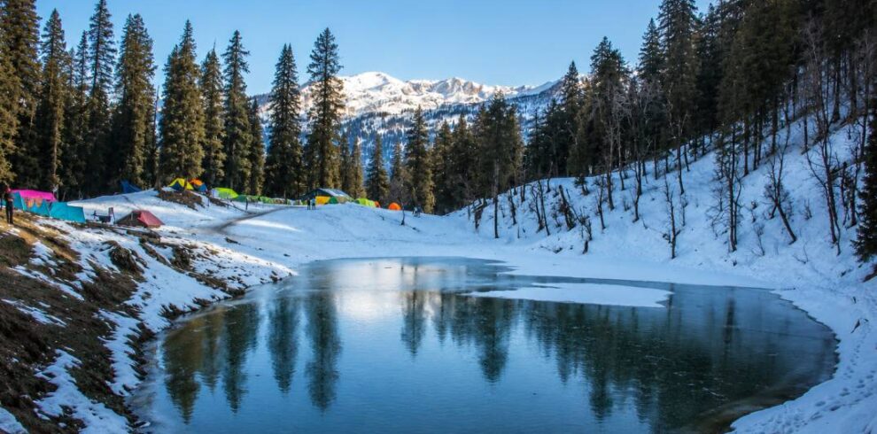 Scenic alpine lake Juda Ka Talab surrounded by dense pine forests on Kedarkantha trek route in Uttarakhand